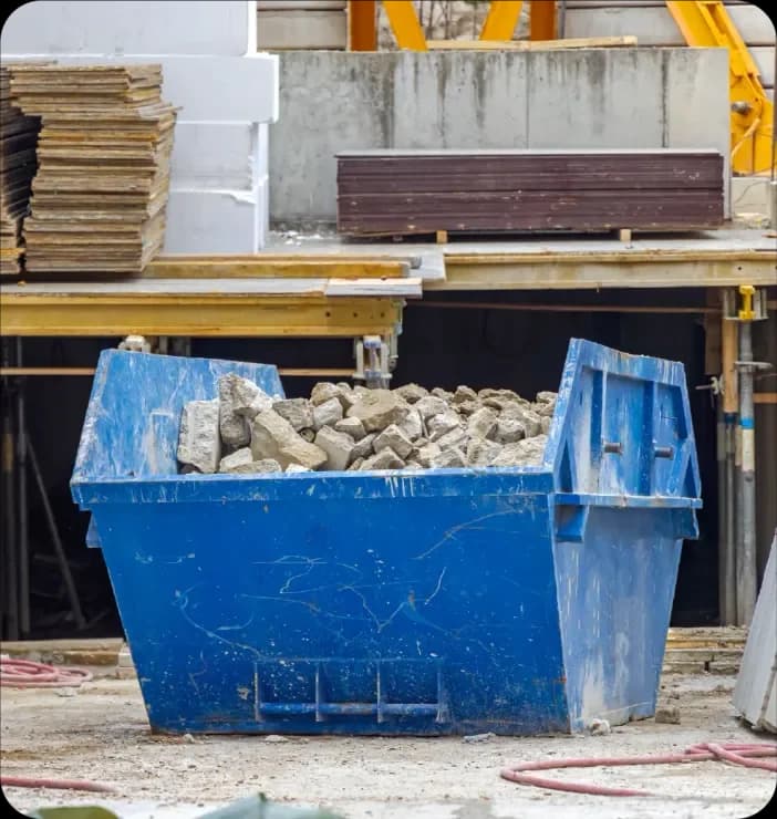 Blue construction skip filled with site debris at a building project